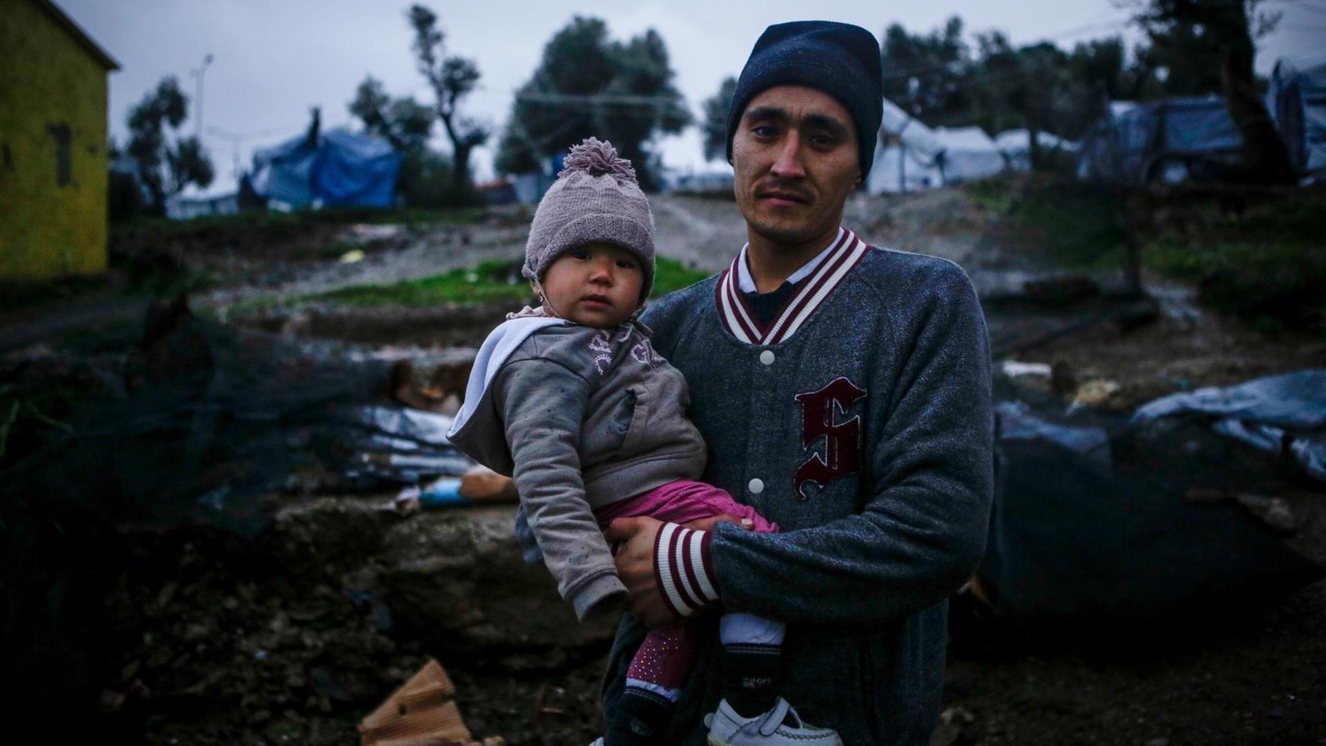 Das Bild zeigt einen Flüchtling mit Kind im Flüchtlingslager Moria auf Lesbos.