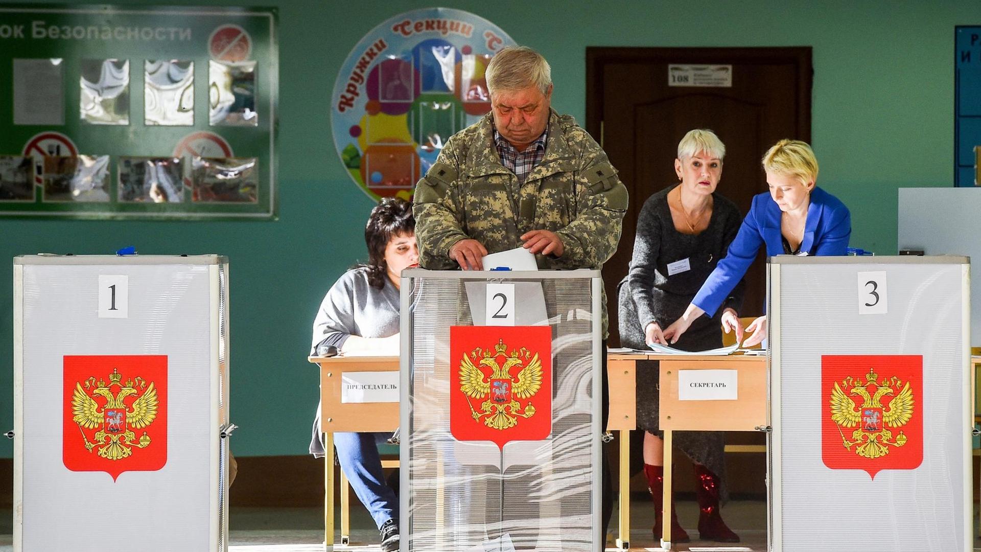 Ein Mann wirft seinen Stimmzettel bei den Regionalwahlen in der Stadt Kostroma in eine Urne.