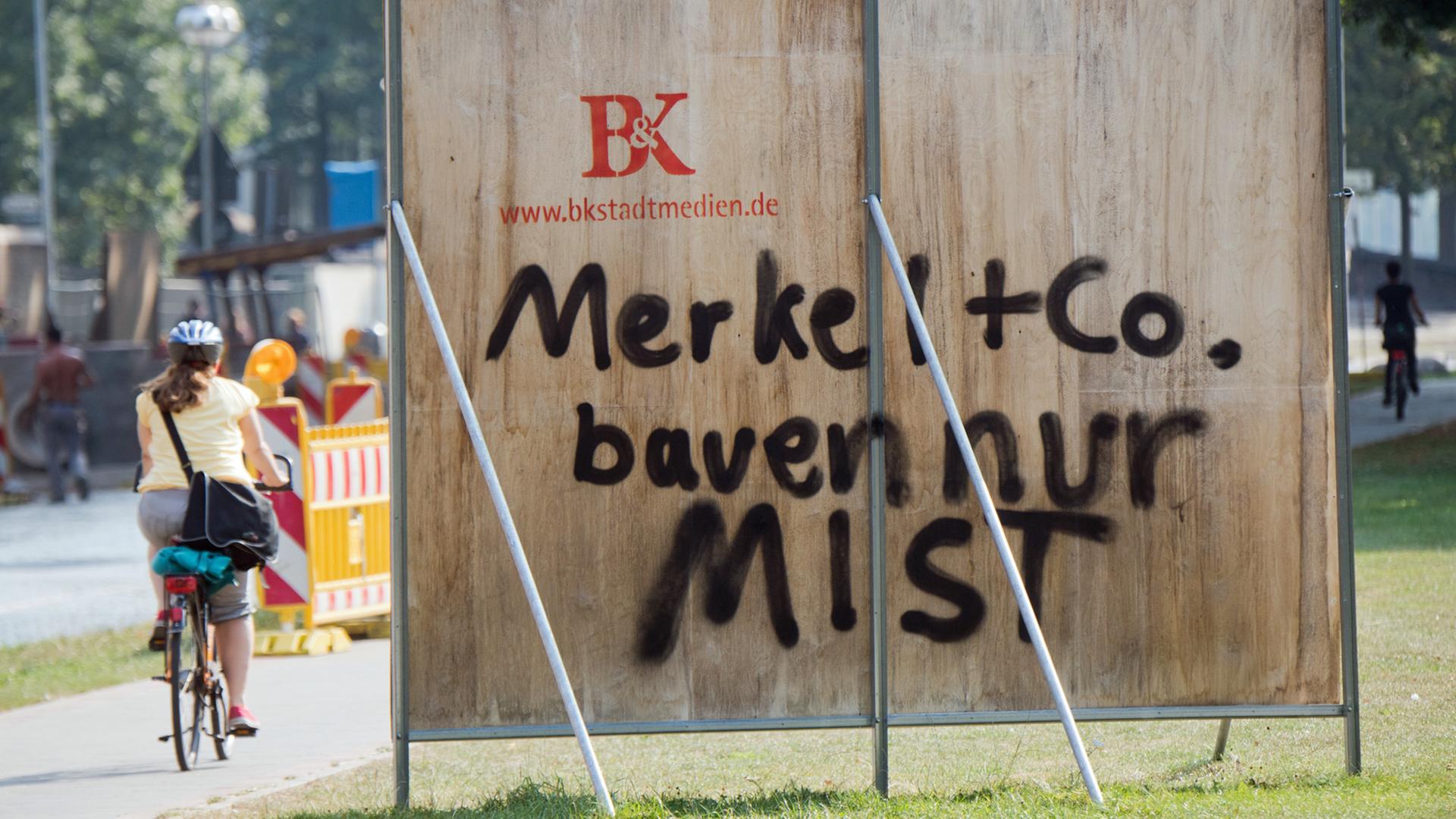 Ein Schriftzug "Merkel + Co. bauen nur Mist" auf einer Plakatwand in Hannover