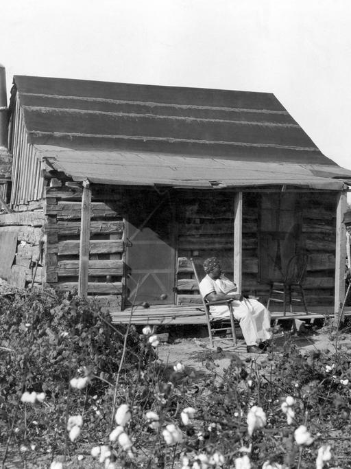 Sklaven im Jahre 1895 vor ihrer Hütte auf einem Baumwollfeld.