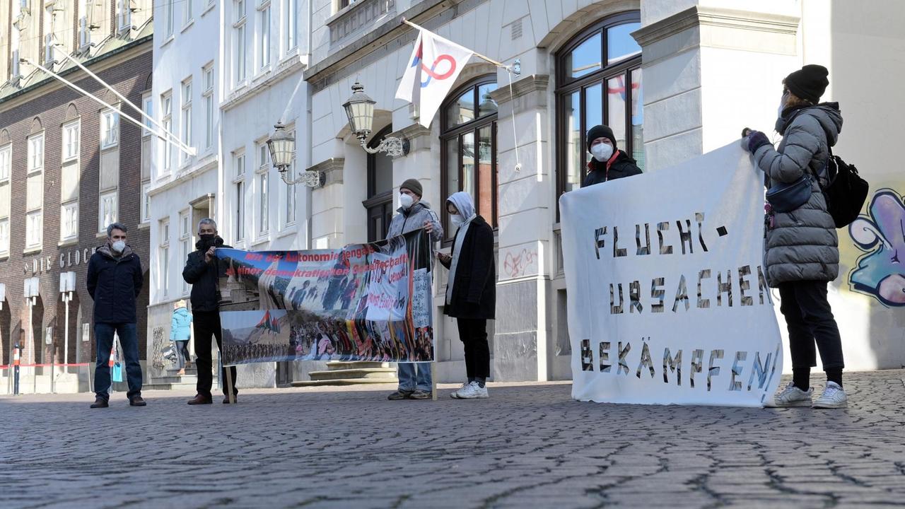 Bremen: Demonstranten stehen mit Transparenten vor dem Bremer Konzerthaus, während der Prozess gegen die ehemalige Leiterin der Bremer Außenstelle des Bundesamtes für Migration und Flüchtlinge (BAMF) in dem Haus ausgerichtet wird.