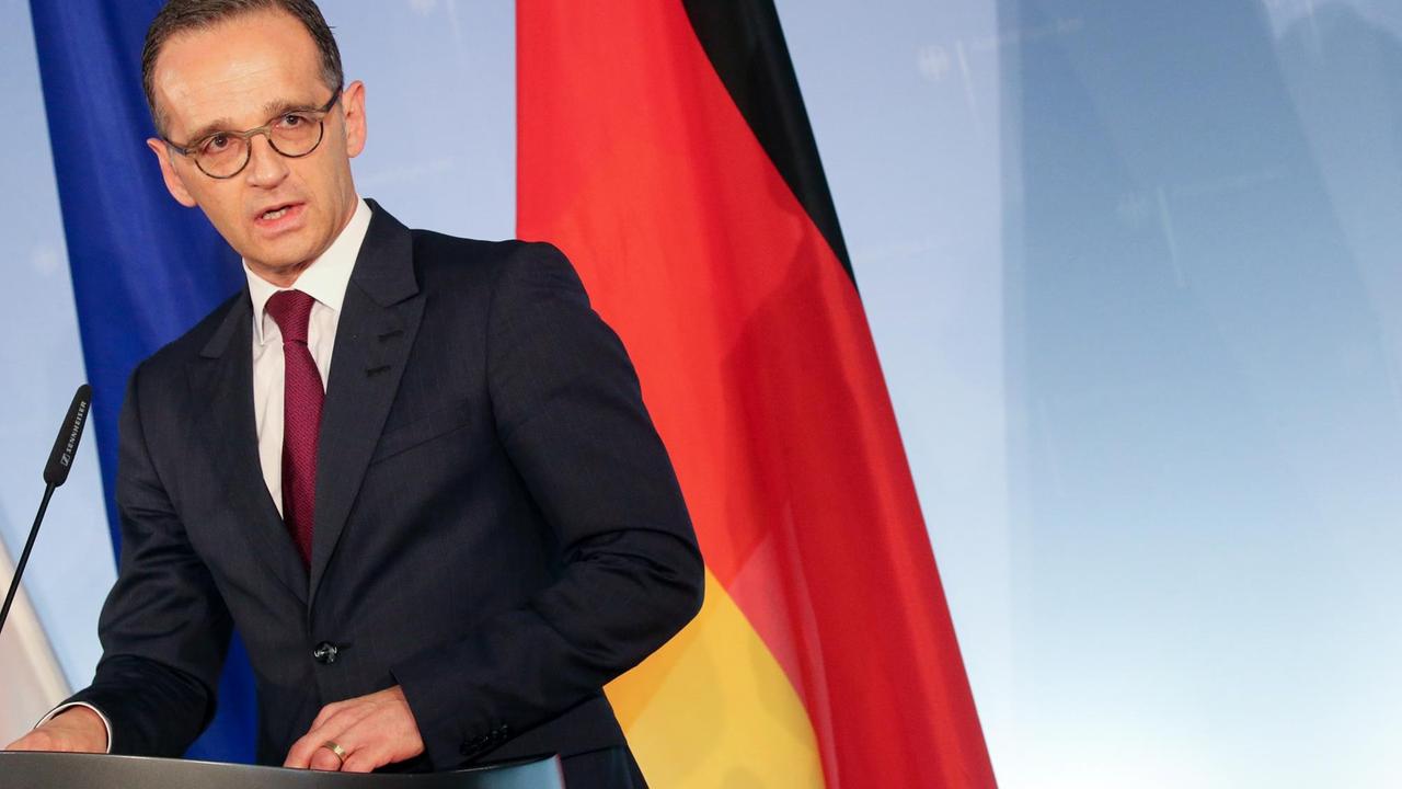 Bundesaußenminister Heiko Maas (SPD) steht im Auswärtigen Amt vor einer deutschen und einer EU-Flagge.