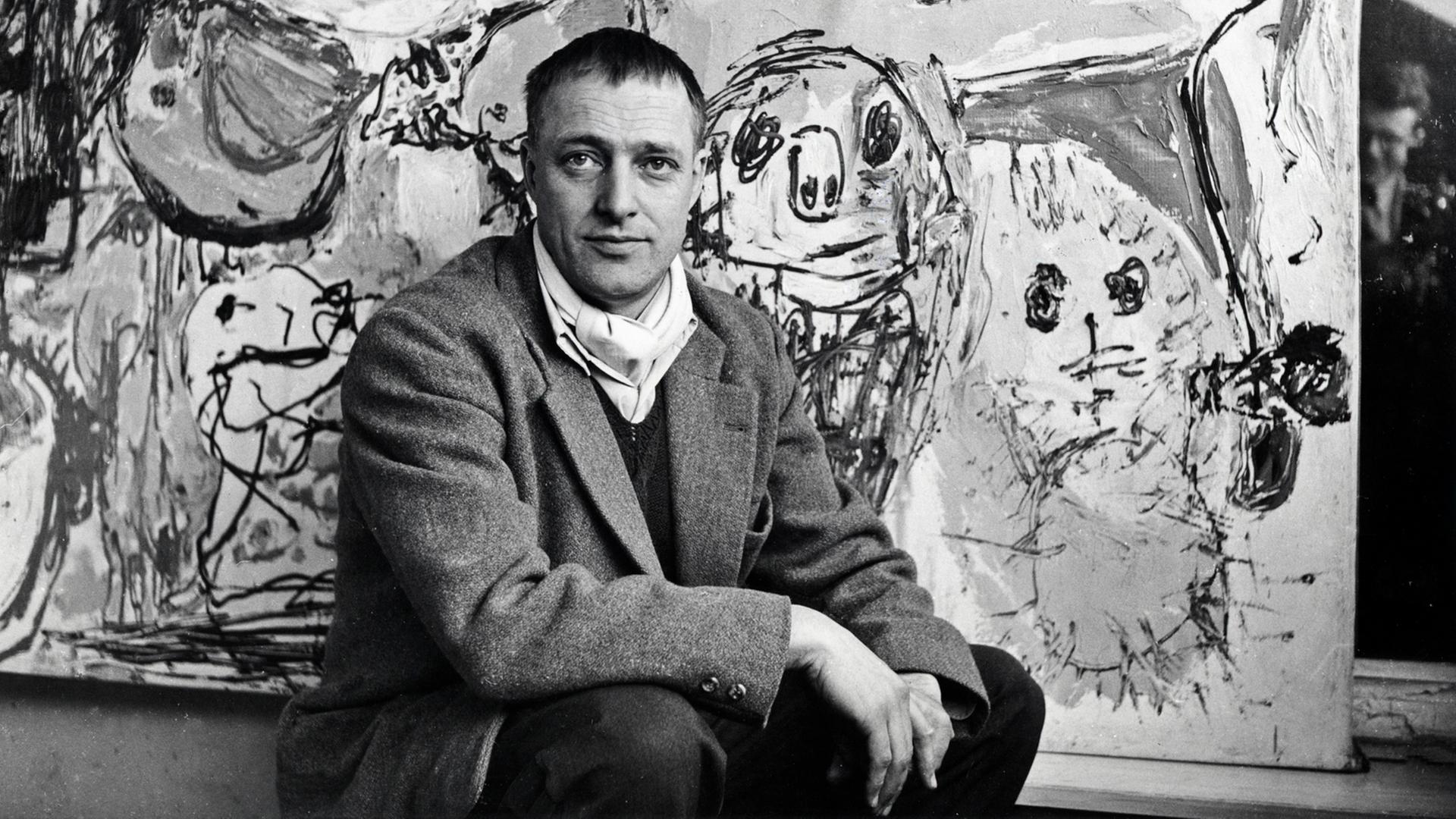 Der dänische Künstler Asger Jorn sitzt vor dem Gemälde "Lettre à mon fils", 1957