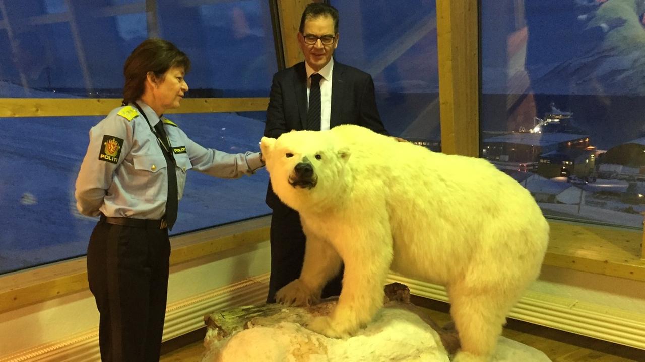 Kjerstin Askholt und Gerd Müller stehen hinter einem ausgestopften Eisbären