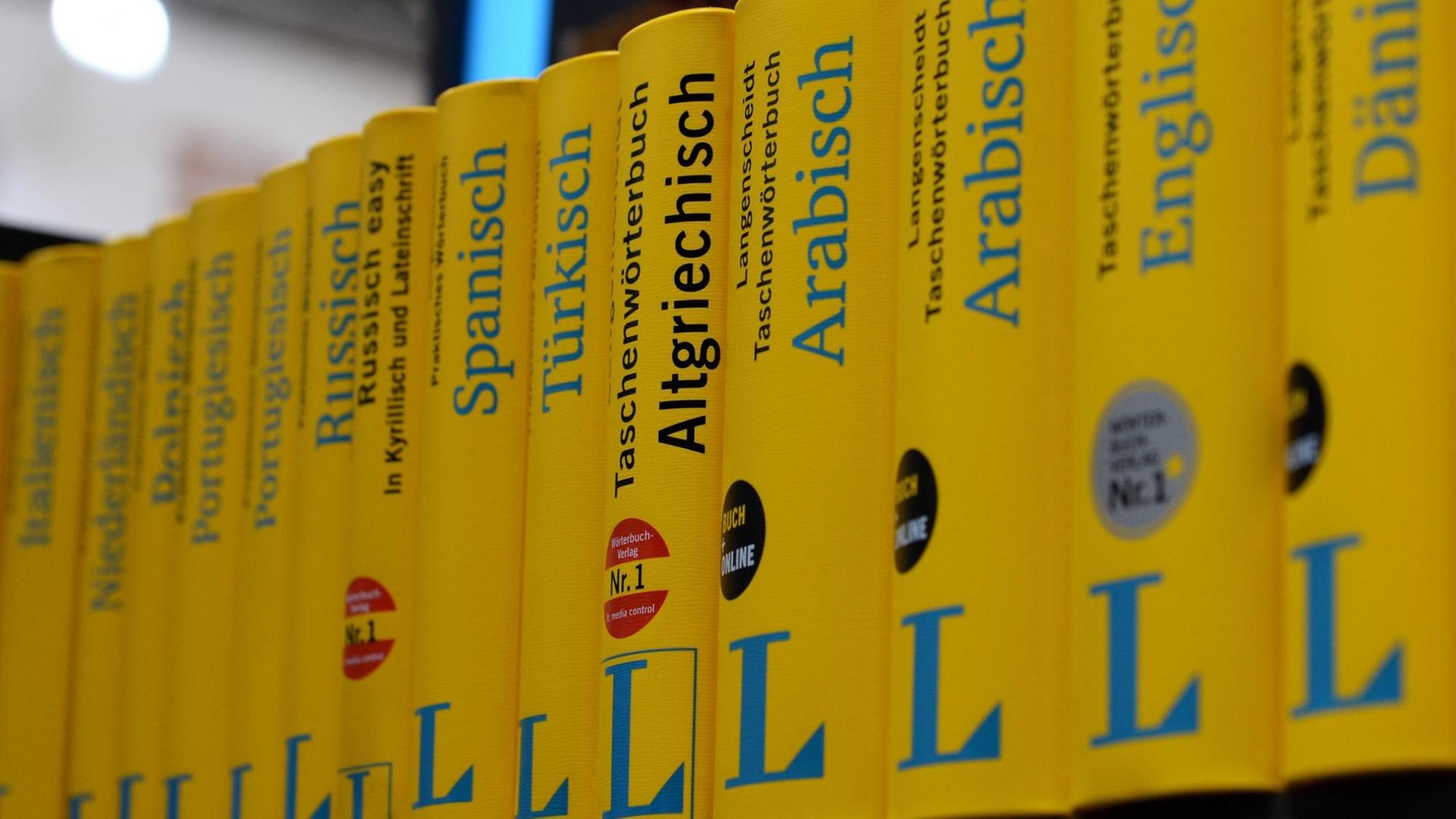 Gelbe Wörterbücher aus dem Langenscheidt Verlag, fotografiert in einer Reihe. Das Wörterbuch "Altgriechisch" sticht mittig aus der Reihe hervor, da in schwarzer statt blauer Schrift gedruckt ist.