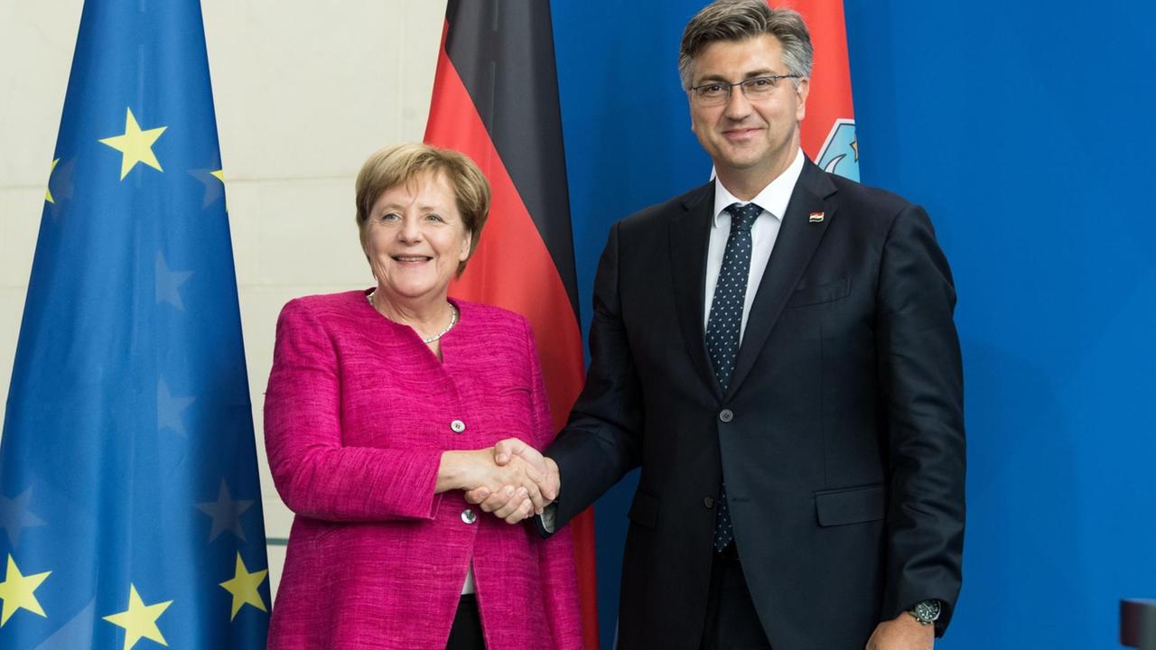 28.08.2018, Berlin: Bundeskanzlerin Angela Merkel (CDU) und Andrej Plenkovic, Ministerpräsident von Kroatien, geben sich nach einer Pressekonferenz im Anschluss ihres Gesprächs im Bundeskanzleramt die Hand. Foto: Bernd von Jutrczenka/dpa | Verwendung weltweit