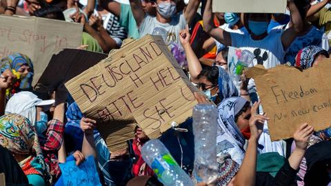 Am 11. September 2020 protestieren Flüchtlinge mit Schildern vor dem ausgebrannten Lager Moria