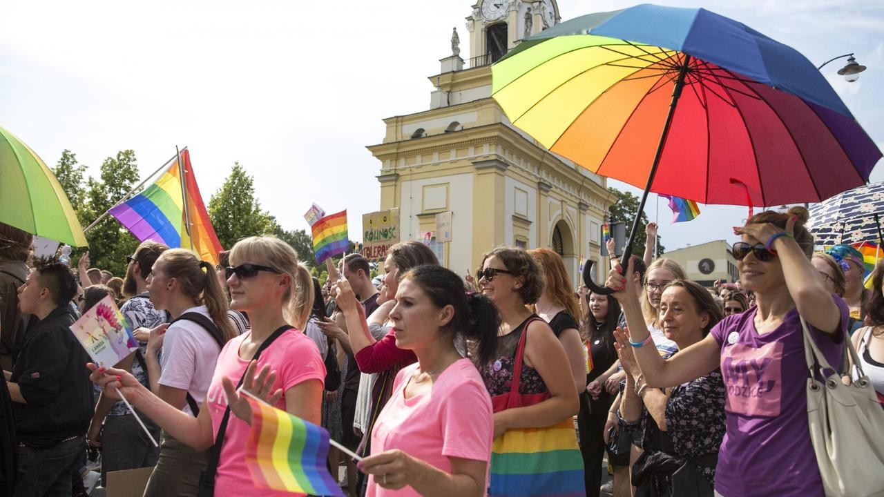 Mit Schirmen und Regenbogenfahnen ziehen Demonstranten durch die Innenstadt von Bialystok.