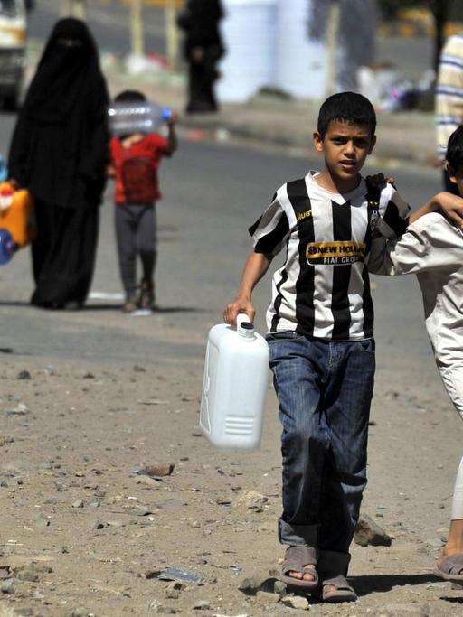 Kinder in der jemenitischen Hauptstadt Sanaa tragen Wasserkanister.