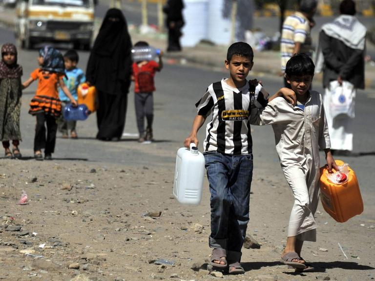 Kinder in der jemenitischen Hauptstadt Sanaa tragen Wasserkanister.