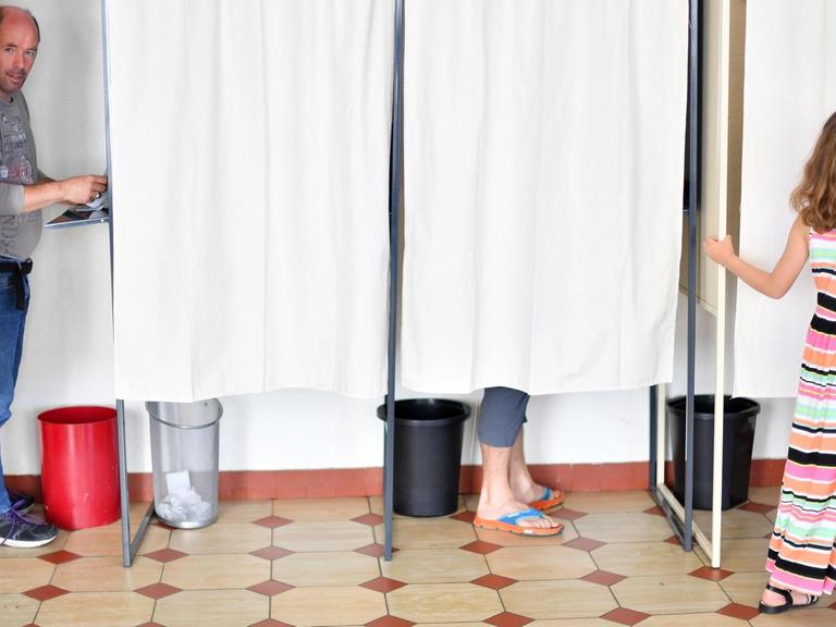 In Frankreich wird eine neue Nationalversammlung gewählt - das Bild zeigt Wahlkabinen, in denen Bürger votieren.