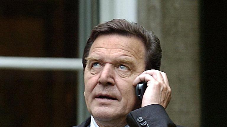 Telefonierend steht Bundeskanzler Gerhard Schröder am Mittwoch (26.05.2004) in Berlin nach einem Fototermin vor einem Gästehaus der Bundesregierung. Der scheidende Bundespräsident hatte die Bundesregierung zu einem Abendessen eingeladen. Foto: Bernd Settn