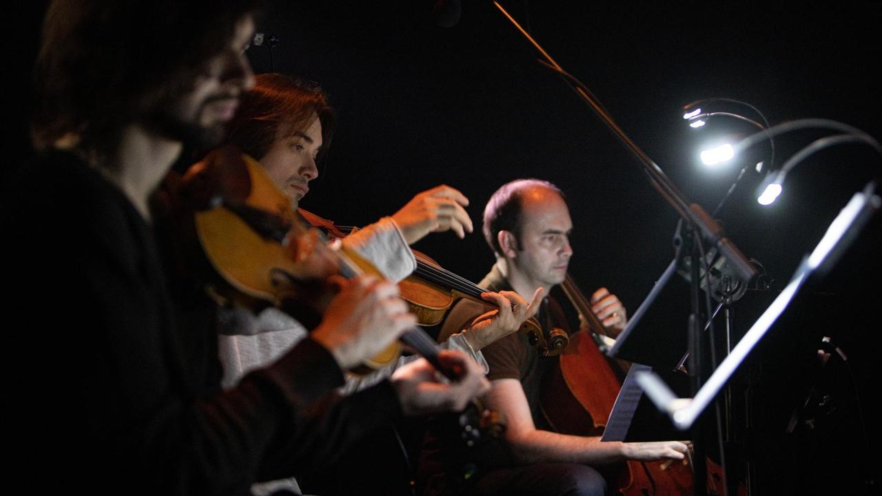 Musiker mit Instrumenten vor einem dunklen Hintergrund beim Festival Territoriya in Moskau.