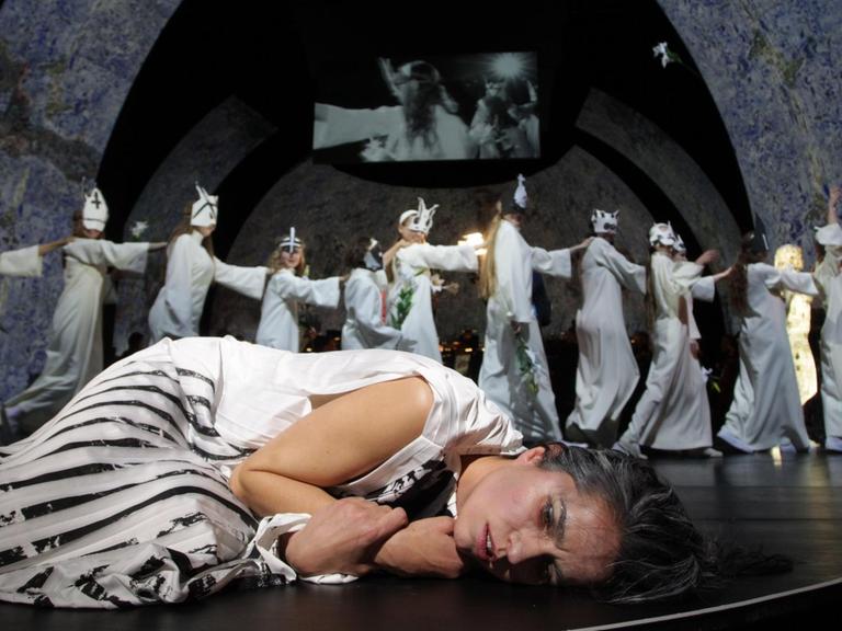 Nadine Lehner liegt auf der Bühne, im Hintergrund der Kinderchor des Theater Bremen.