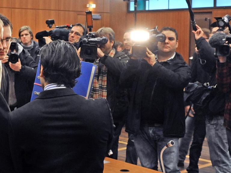 Ein Angeklagter vor dem Landgericht Frankfurt versucht, den Blicken der Öffentlichkeit zu entgehen. /Symbolbild