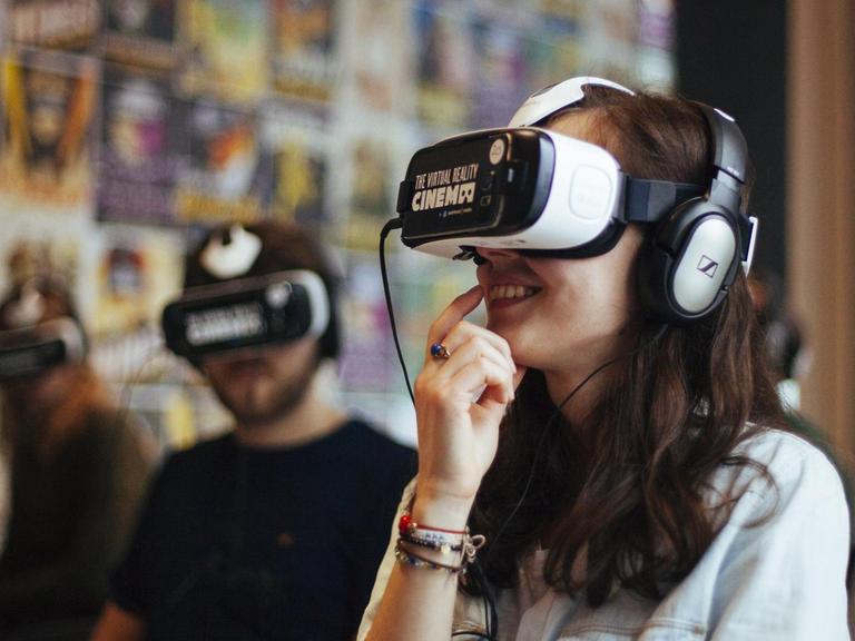 Bild zeigt Gäste des Virtual-Reality-Kinos von Amsterdam, die eine Virtual-Reality-Brille tragen