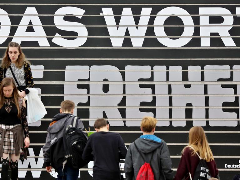 Besucher gehen am 23.03.2017 über eine Treppe mit den Schriftzug "Für das Wort und die Freiheit" auf der Buchmesse in Leipzig.