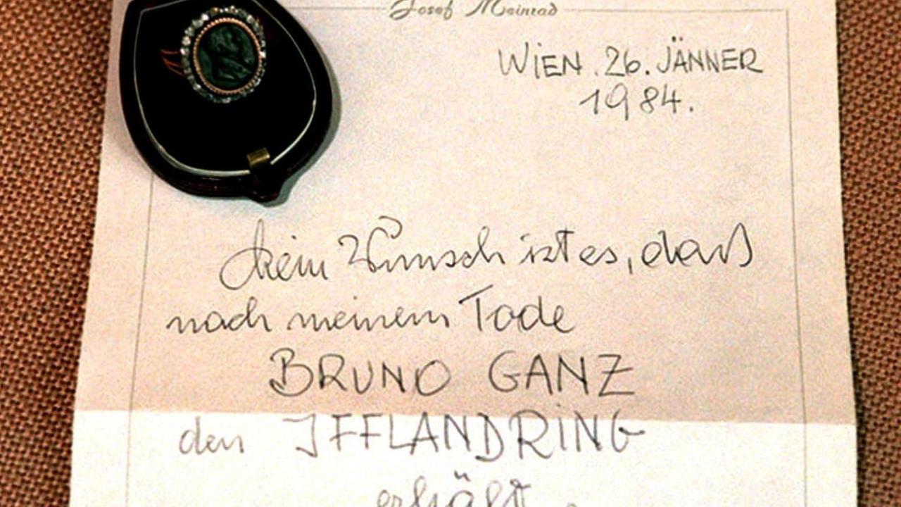 Das Bild zeigt das vom Burgschauspieler Josef Meinrad am 26.Januar 1984 verfaßte Testament über die Weitergabe des Iffland-Rings nach seinem Tod. Darin steht: "Mein Wunsch ist es, daß nach meinem Tode BRUNO GANZ den IFFLANDRING erhält. Josef Meinrad". Links oben, der Ring in einer Schatulle.