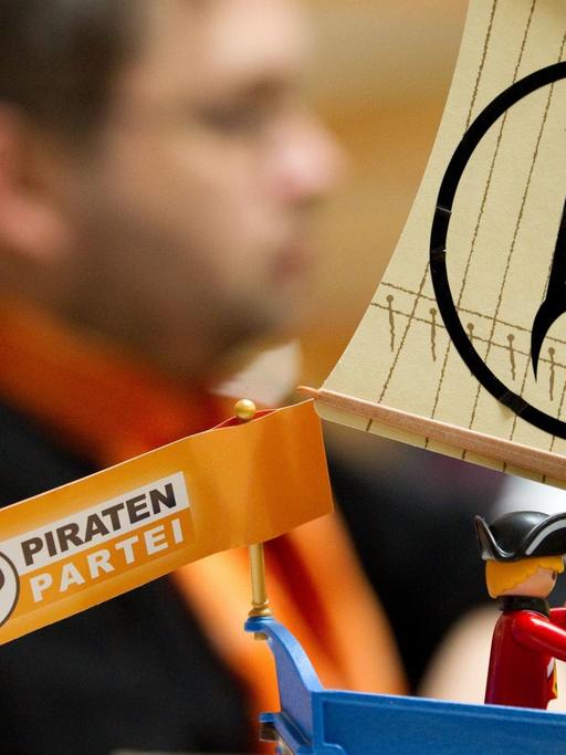 Ein Parteimitglied sitzt neben dem Modell eines Piratenschiffes.