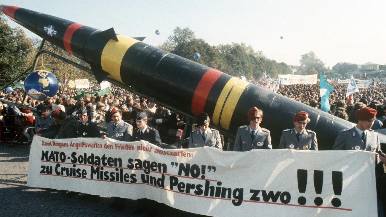 Trotz Verbots nehmen Soldaten der Bundeswehr in Uniform am 22.10. 1983 an einer Großkundgebung im Bonner Hofgarten teil und demonstrieren mit einem Transparent und einer Pershing-II-Attrappe gegen die NATO-Hochrüstung.