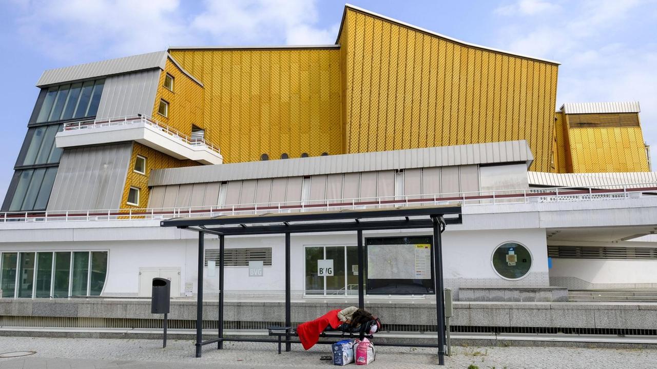 Ein obdachloser Mensch schläft im Juli einem Wartehaeuschen der BVG vor dem Kammermusiksaal im Berliner Tiergartenviertel.