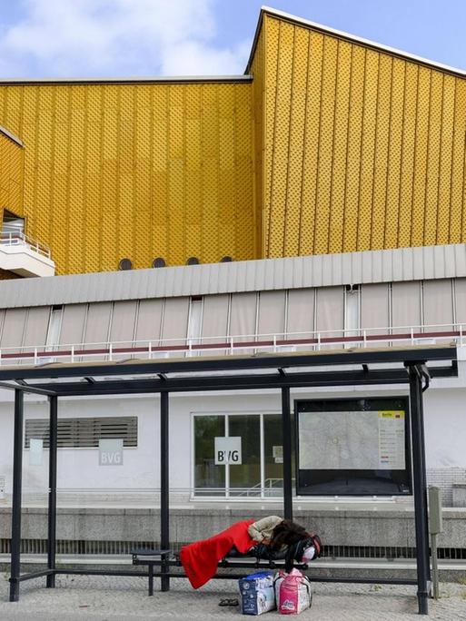 Ein obdachloser Mensch schläft im Juli einem Wartehaeuschen der BVG vor dem Kammermusiksaal im Berliner Tiergartenviertel.