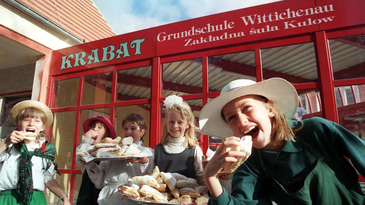 Glückliche Kinder in Wittichenau essen selbstgebackenen Apfeltaschen.