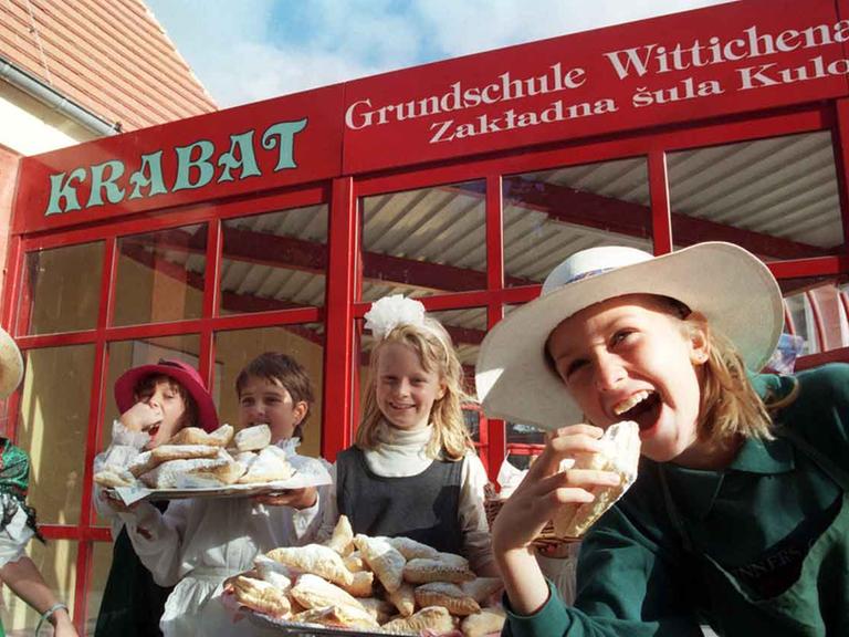 Glückliche Kinder in Wittichenau essen selbstgebackenen Apfeltaschen.