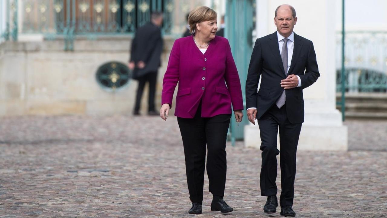 Bundeskanzlerin Angela Merkel (CDU) und Olaf Scholz (SPD), Bundesfinanzminister, nach der Klausurtagung des neuen Bundeskabinetts im Schloss Meseberg auf dem Weg zu einer Pressekonferenz.
