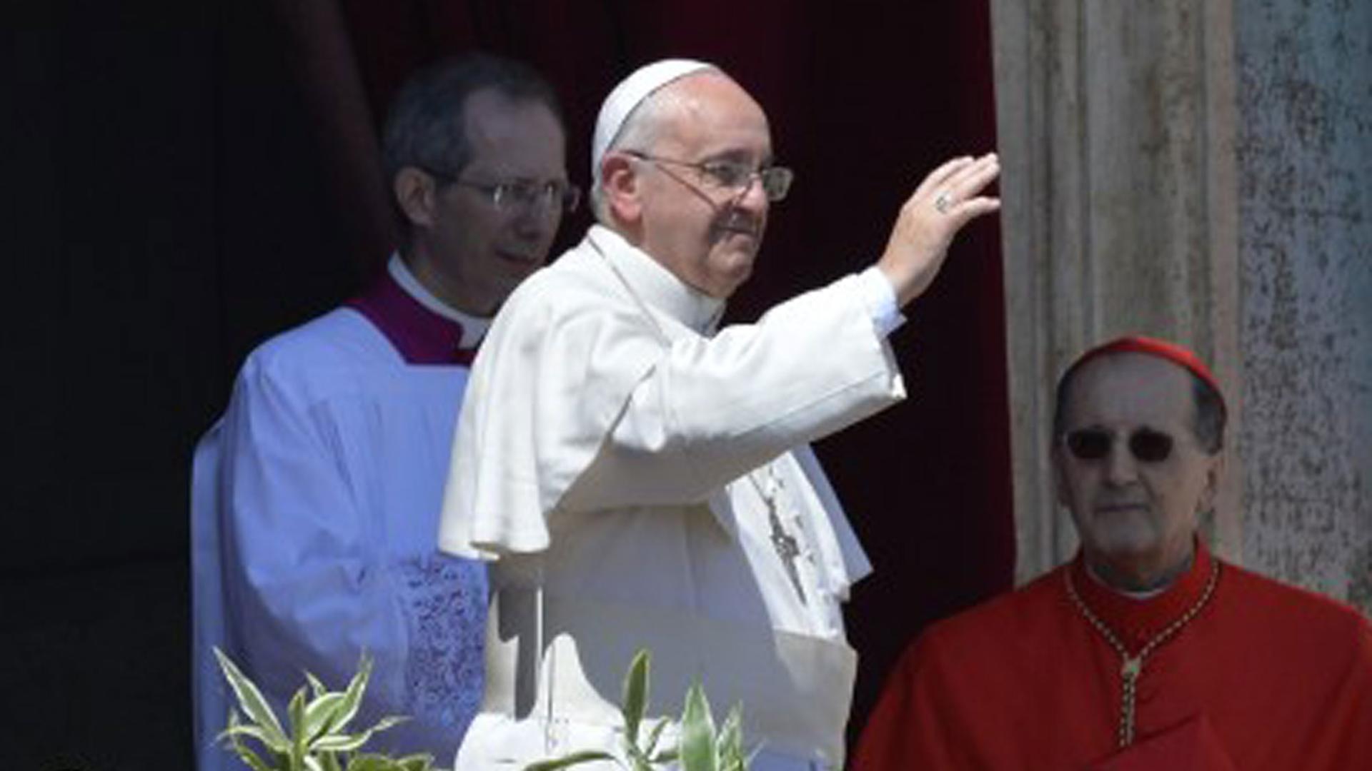 Papst Franziskus spendete den traditionellen Ostersegen "Urbi et Orbi". Er steht auf einem Balkon am Petersplatz und hebt die Hand zum segnen. Im Hintergrund sind weitere Würdenträger zu sehen.