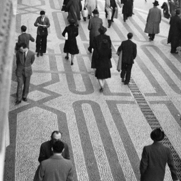 Schwarzweißfoto: Passanten am Rossio-Platz in Lissabon