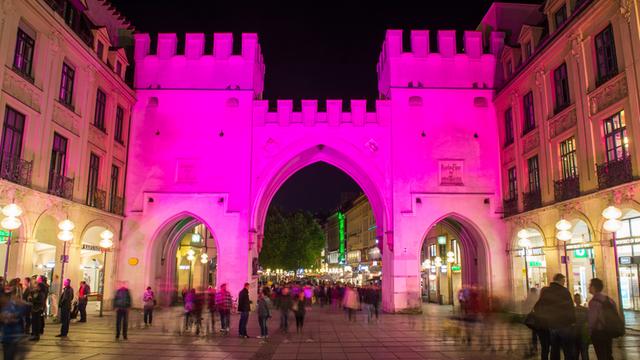 Das Karls-Tor in der Stadt München ist pink beleuchtet.
