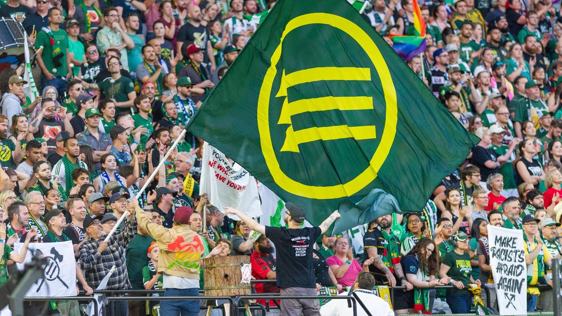 Portland-Fans mit einer Fahne, auf dem das Symbol der Eisernen Front zu sehen ist