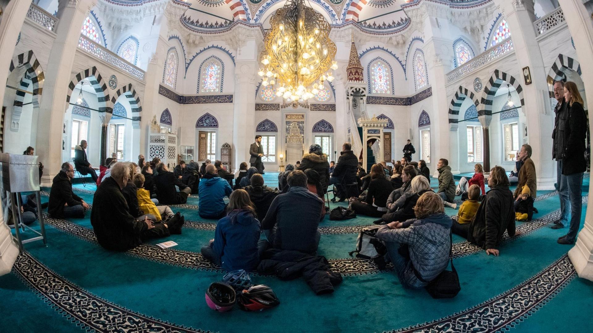 Menschen sitzen in einer Moschee auf dem Teppich. Menschen sitzen in einer Moschee auf dem Teppich.