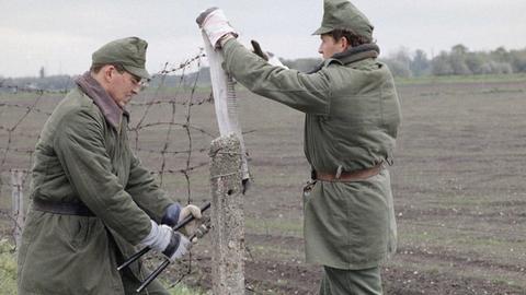 Ungarische Grenzbeamte schneiden im Mai 1989 an der Grenze zu Österreich ein Loch in den "Eisernen Vorhang"
