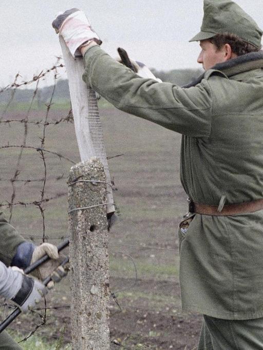 Ungarische Grenzbeamte schneiden im Mai 1989 an der Grenze zu Österreich ein Loch in den "Eisernen Vorhang"