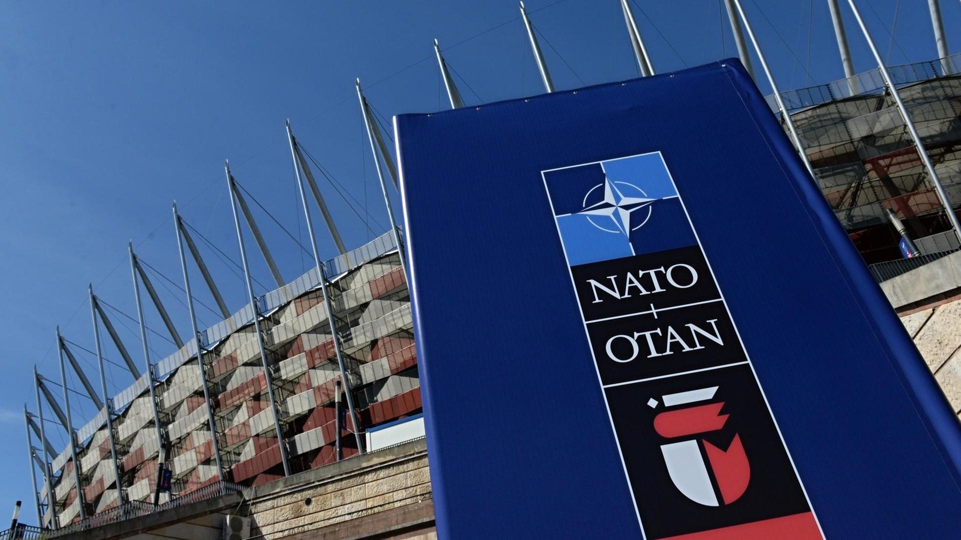 Ein Schild mit der Aufschrift Nato vor dem Stadion in Polens Hauptstadt Warschau