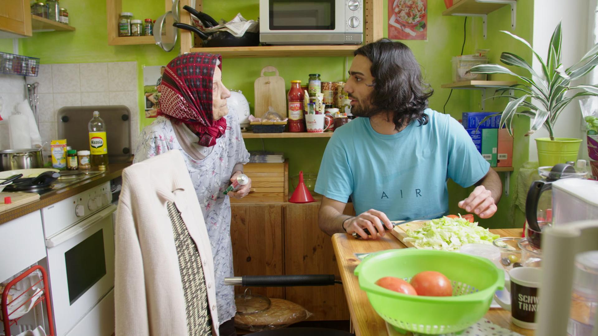 Szene aus der Generationen-Langzeitbeobachtung "20-40-60: Unser Leben!" des ZDF: Der 20-jährige Ehsan ist mit seiner 93-jährigen Großmutter, mit der er gemeinsam in einer Wohnung lebt, in der Küche zu sehen.