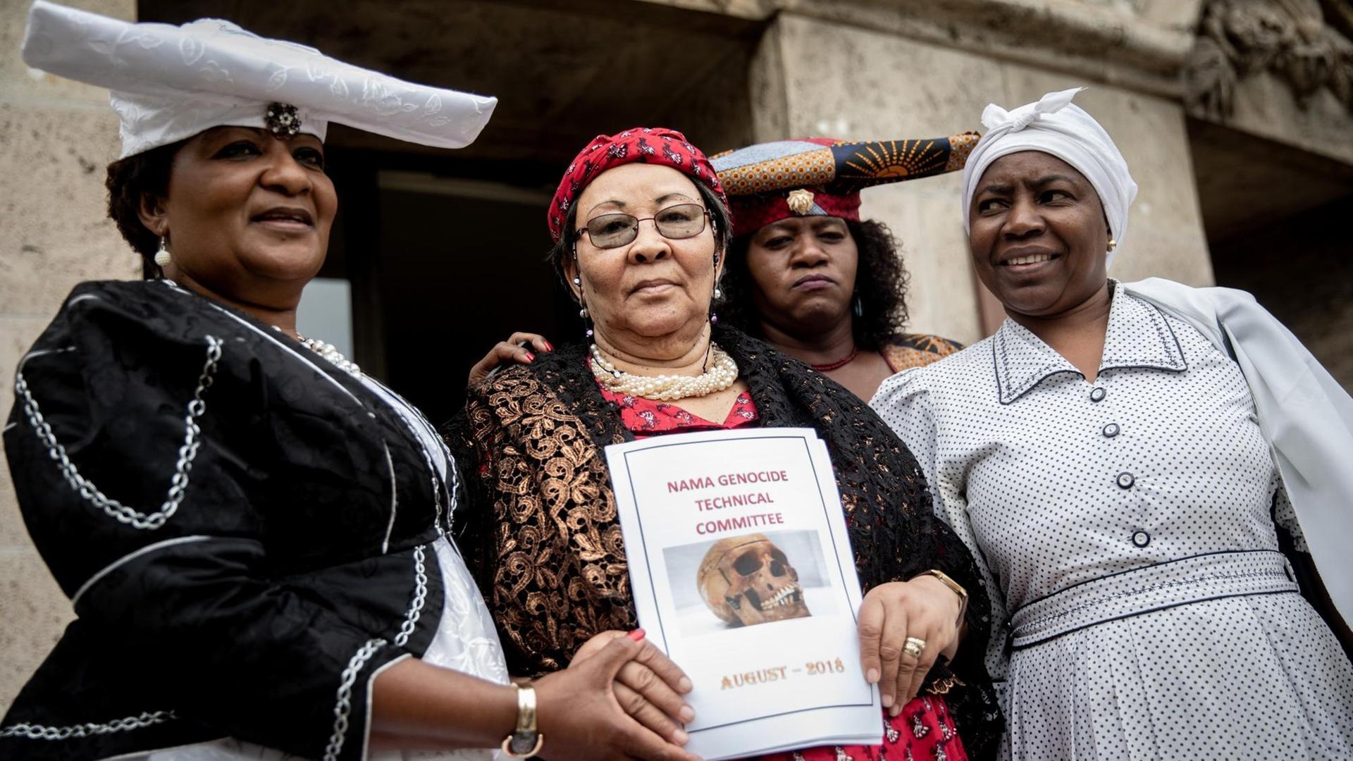 27.08.2018, Berlin: Eine Delegation von Ovaherero und Nama aus Namibia, Esther Utjiua Muinjangue (l), Vorsitzende der Ovaherero Genocide Foundation in Namibia, Ida Hoffmann (2.v.l), Parlamentsabgeordnete und Vorsitzende des Nama Genocide Technical Committee in Namibia und weiteren Delegationsmitgliedern stehen nach einem Treffen und einer Pressekonferenz mit Justizsenator Behrendt (nicht im Bild) vor der Senatsverwaltung für Justiz, Verbraucherschutz und Antidiskriminierung.