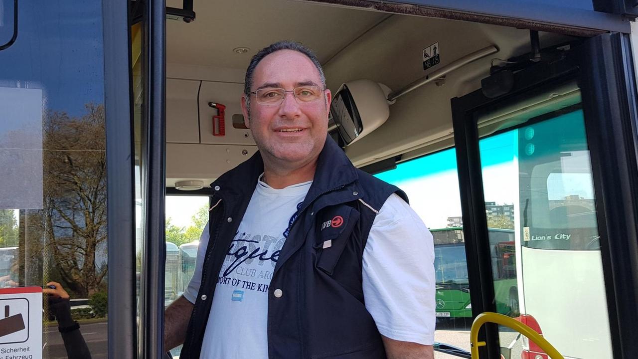 Thorsten Kleefisch lehnt an der Tür eines KVB-Busses