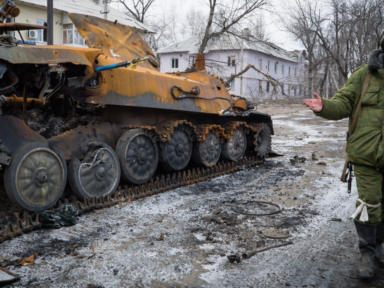 Ein prorussischer Rebell neben einem zerstörten Panzerfahrzeug in der Stadt Vuglegirsk, Region Donetzk.