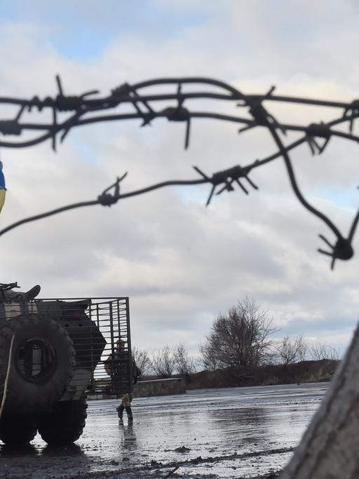 Ukrainische Soldaten hinter einem Stacheldrahtzaun