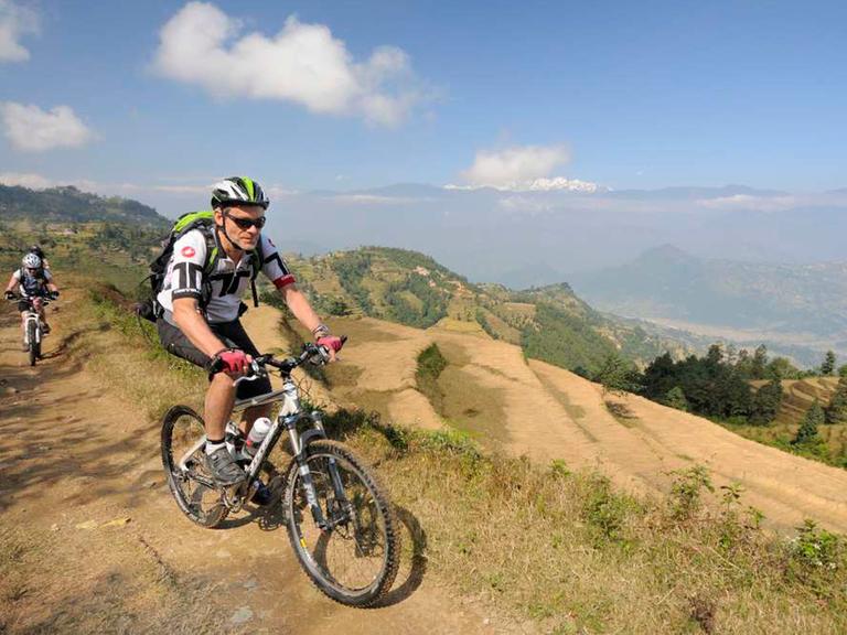 Eine Mann fährt auf einem Mountainbike durch die Berge. 