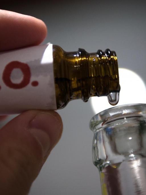 In einer gestellten Szene werden "K.O.- Tropfen" in eine Bierflasche gefüllt