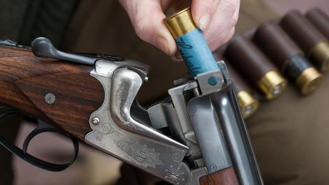 Ein Jäger steckt eine Patrone mit bleihaltiger Munition in seine Flinte.