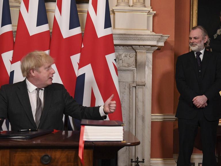 Der britische Botschafter bei der EU Tim Barrow, rechts, schaut zu, nachdem Premierminister Boris Johnson das Handels- und Kooperationsabkommen zwischen der EU und Großbritannien unterzeichnet.