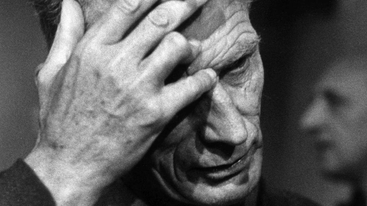 Der Dramatiker Samuel Beckett greift sich am 23.09.1967 auf der Studiobühne des Berliner Schiller-Theaters bei den Theaterproben zu seinem Stück "Endspiel" an die Stirn. In seiner Hand hält er eine Zigarette.