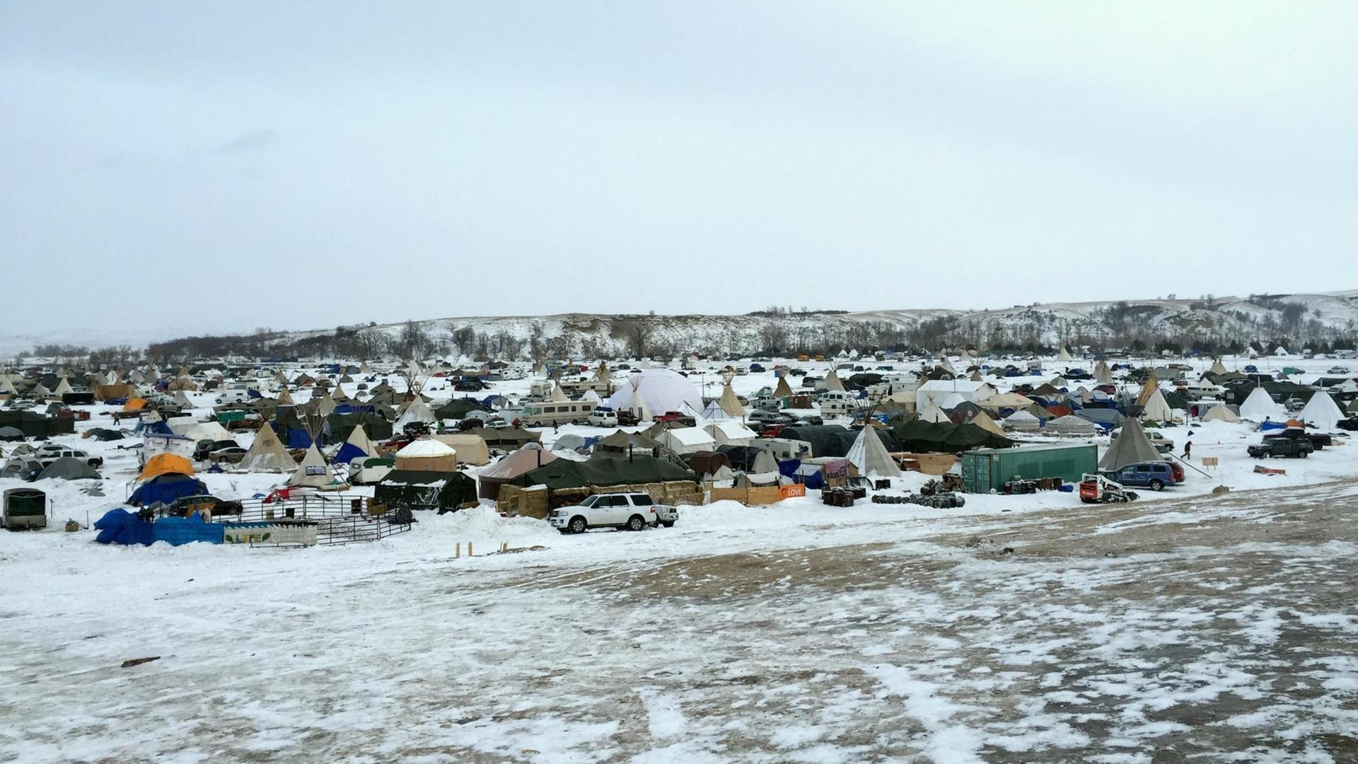 Von einem Hügel sieht man hunderte Zelte im Schnee von Demonstranten gegen die Öl-Pipeline.