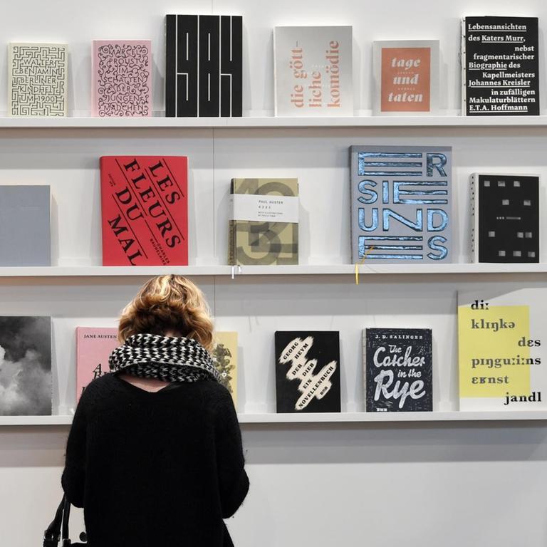 Eine Besucherin der Leipziger Buchmesse 2019 blättert in einem Buch am Stand der Muthesius Kunsthochschule Kiel.