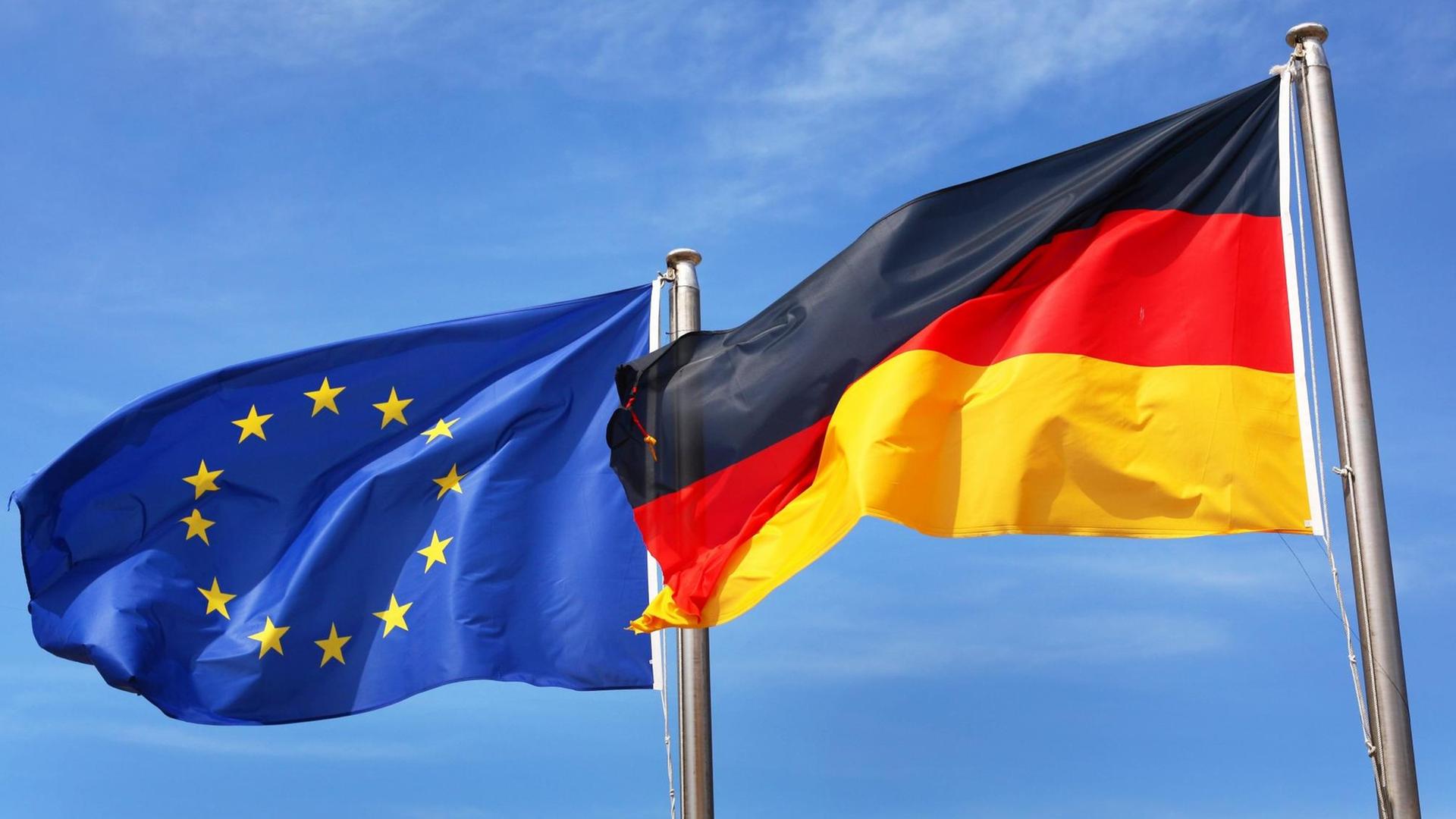 Die Deutsche Flagge und die Europaflagge flattern im Wind